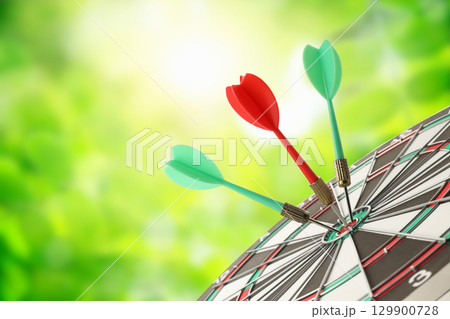 Three darts striking a dartboard under soft sunlight in nature Three darts striking a dartboard under soft sunlight in nature 129900728