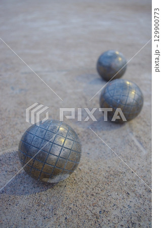 Three silver balls are sitting on a grey surface Three silver balls are sitting on a grey surface 129900773