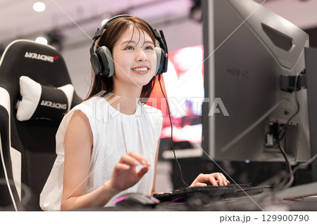 eスポーツの大会でゲームを楽しむ若い女性 129900790
