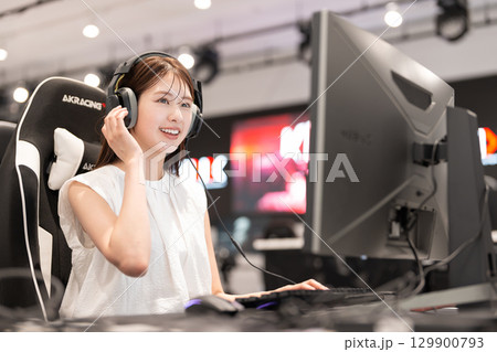 eスポーツの大会でゲームを楽しむ若い女性 129900793