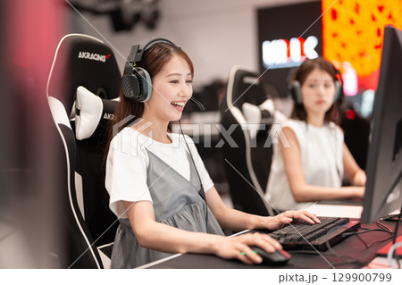 eスポーツの大会でゲームを楽しむ若い女性 129900799