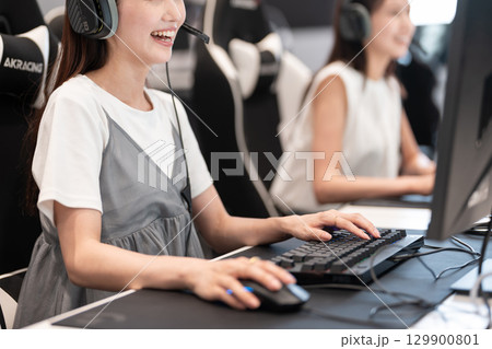 eスポーツの大会でゲームを楽しむ若い女性 129900801