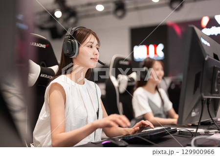 eスポーツの大会でゲームを楽しむ若い女性 129900966
