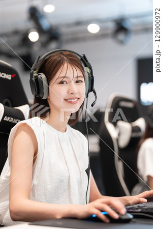 eスポーツの大会でゲームを楽しむ若い女性 129900972