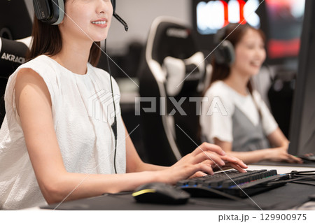 eスポーツの大会でゲームを楽しむ若い女性 129900975