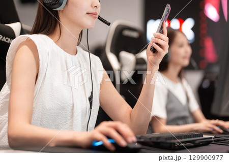 eスポーツの大会でゲームを楽しむ若い女性 129900977