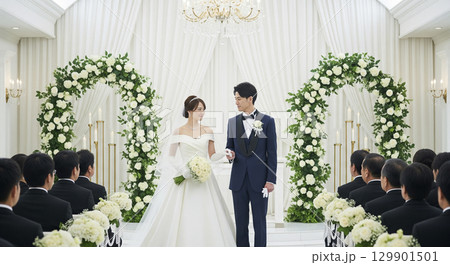 チャペルで結婚式　参列者に祝福される新郎新婦 129901501