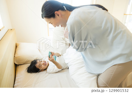 寝転んでスマホを見る子供 129901532