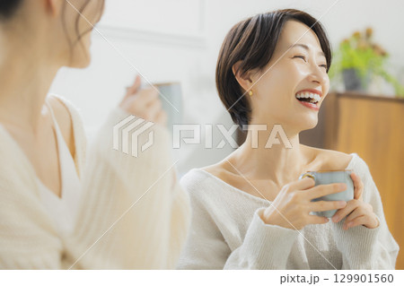部屋でホットコーヒーを飲む女性  129901560