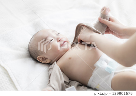 赤ちゃんのお世話をする若い母親　  129901679
