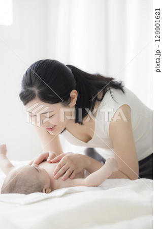 赤ちゃんのお世話をする若い母親　  129901681