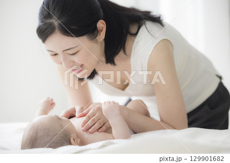 赤ちゃんのお世話をする若い母親　  129901682