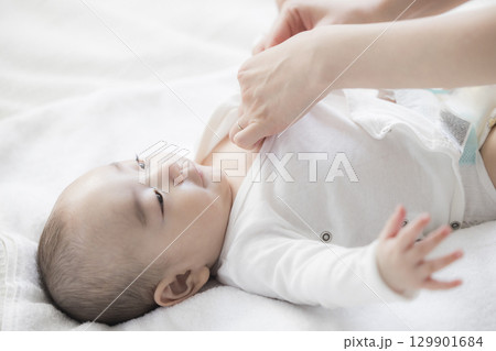赤ちゃんのお世話をする若い母親 赤ちゃんのお世話をする若い母親 129901684
