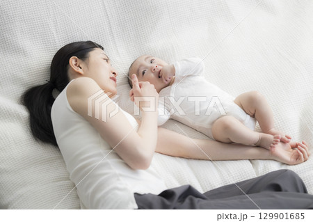 赤ちゃんのお世話をする若い母親 赤ちゃんのお世話をする若い母親 129901685