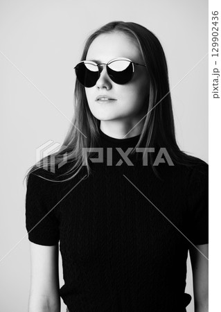 Close-up studio portrait of beautiful woman with sunglasses 129902436