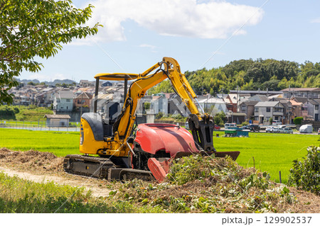 油圧ショベルと草刈り重機 129902537