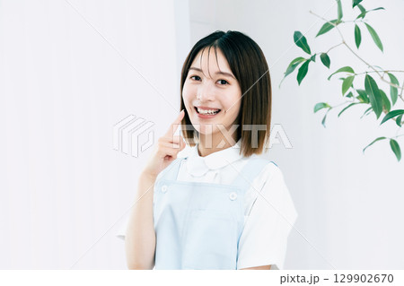 歯を指差す歯科スタッフの女性 129902670