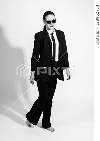 Woman with classic black suit and sunglasses Woman with classic black suit and sunglasses 129902753
