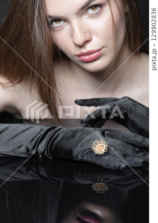Close-up studio portrait of beautiful woman with fancy golden ring and black gloves Close-up studio portrait of beautiful woman with fancy golden ring and black gloves 129902836