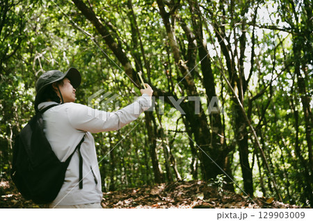 Young female traveler with backpack walking in national park or forest. recreation sport in nature. Female person bag, wave for hiking journey in woods. adventure in forest. trekking with backpack Young female traveler with backpack walking in national park or forest. recreation sport in nature. Female person bag, wave for hiking journey in woods. adventure in forest. trekking with backpack 129903009