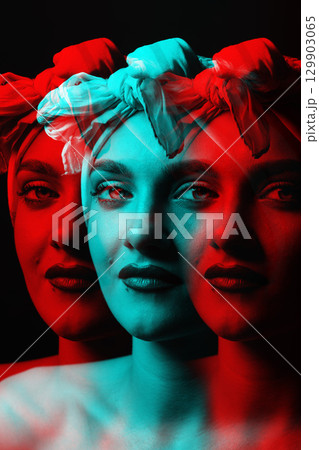 Portrait of beautiful woman with white scarf on her head looking at camera in RGB color split effect 129903065