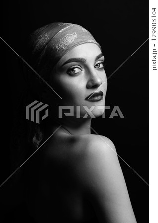 Woman with scarf on her head black and white studio portrait 129903104