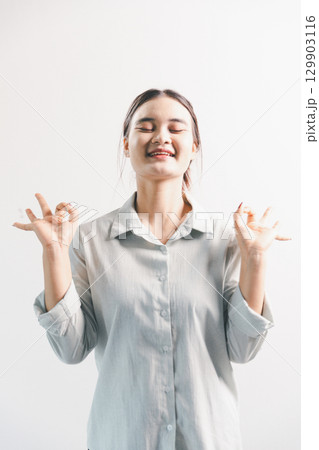 Asian woman rejoicing, looking happy, champion, fist pump gesture, standing over white background. young woman had happy, positive expression on her face, highlighted by bright smile. Asian woman rejoicing, looking happy, champion, fist pump gesture, standing over white background. young woman had happy, positive expression on her face, highlighted by bright smile. 129903116