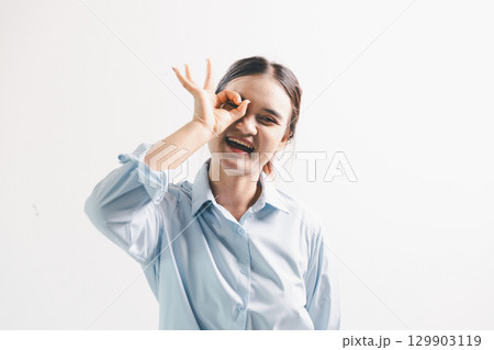 Asian woman rejoicing, looking happy, champion, fist pump gesture, standing over white background. young woman had happy, positive expression on her face, highlighted by bright smile. Asian woman rejoicing, looking happy, champion, fist pump gesture, standing over white background. young woman had happy, positive expression on her face, highlighted by bright smile. 129903119