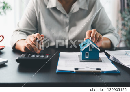 Real estate agent agree to buy home to clients agency office. House model, real estate agent, customer discussing for contract to buy house, insurance, loan real estate background. Concept agreement. Real estate agent agree to buy home to clients agency office. House model, real estate agent, customer discussing for contract to buy house, insurance, loan real estate background. Concept agreement. 129903123