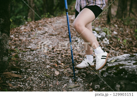 Hiking action on mountain grass trail path. Close up of female hiker shoe. adventurous lifestyle of hiker and backpack to travel and trek mountain, enjoy every walk and hike part of thrilling journey 129903151