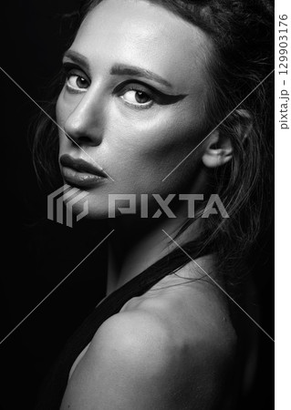 Studio portrait of beautiful woman with eye shadows and dreadlocks 129903176