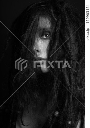 Studio woman portrait with make-up and messy dreadlocks hair covering her face Studio woman portrait with make-up and messy dreadlocks hair covering her face 129903184