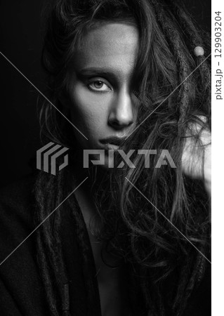 Studio portrait of woman with make-up and hair with dreadlocks Studio portrait of woman with make-up and hair with dreadlocks 129903204