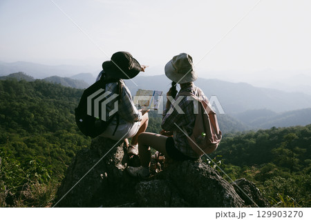 Woman hiker on top of mountain. Hiker with arms up on top of mountain successful young woman enjoying triumph. traveler exploring world. Hikers with backpacks relaxing. Sport and success concept. 129903270