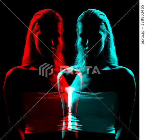 Studio portrait of woman silhouette partly illuminated with light in RGB color split effect style 129903465