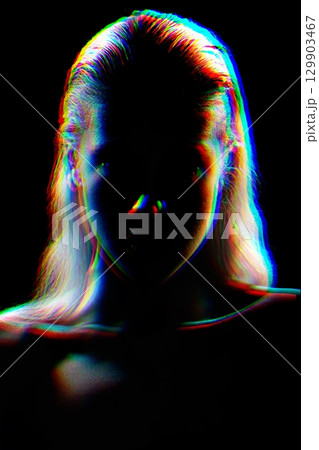 Studio portrait of woman silhouette partly illuminated with light in RGB color split effect style 129903467
