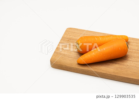 カッティングボードに置かれた人参 129903535