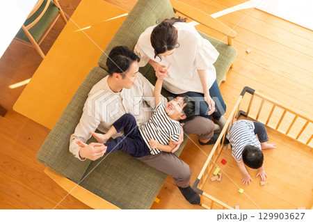 リビングで遊ぶ子供と若い夫婦 129903627