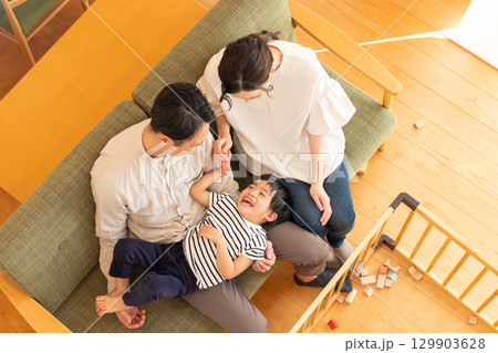 リビングで遊ぶ子供と若い夫婦 129903628