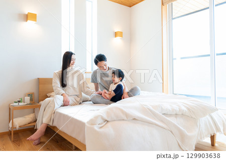 寝室で会話する若い家族 129903638