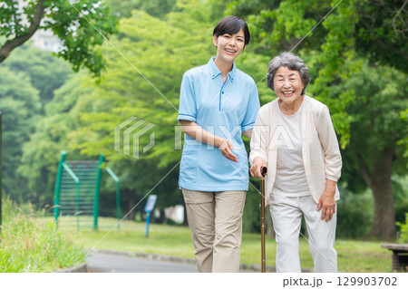 散歩するシニア女性と介護士 129903702