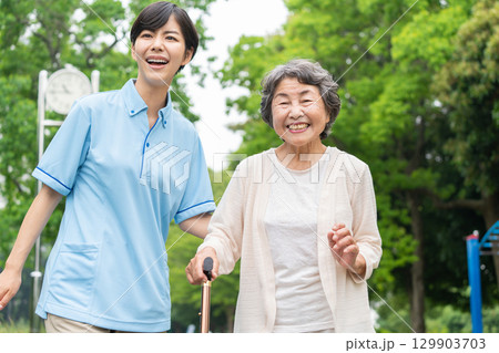 散歩するシニア女性と介護士 散歩するシニア女性と介護士 129903703