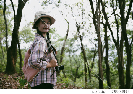 Young female traveler with backpack walking in national park or forest. recreation sport in nature. Female person bag, wave for hiking journey in woods. adventure in forest. trekking with backpack 129903995