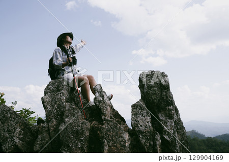 Woman hiker on top of mountain. Hiker with arms up on top of mountain successful young woman enjoying triumph. traveler exploring world. Hikers with backpacks relaxing. Sport and success concept. 129904169