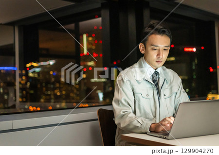 パソコンを操作する作業着を着たビジネスマン 129904270