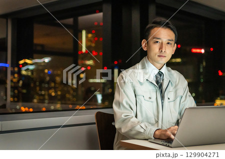 パソコンを操作する作業着を着たビジネスマン 129904271