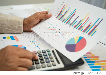 Asian business woman working with financial graph. 129904359