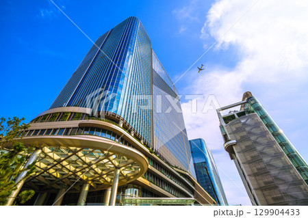 日本の東京都市景観 珍景航空機通過…猛烈な暑さ、発達した雲が高輪ゲートウェイシティ上空に＝8月21日 129904433