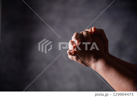 Christian woman lifts her hand in worship to pray, hope, faith, and deep belief in God defines core concept of religion. Praying hands with faith in religion, belief in God. Power of hope or love. Christian woman lifts her hand in worship to pray, hope, faith, and deep belief in God defines core concept of religion. Praying hands with faith in religion, belief in God. Power of hope or love. 129904473