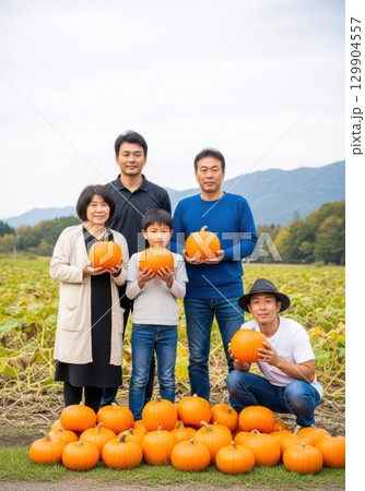 秋の農園でかぼちゃを収穫する家族の写真 129904557
